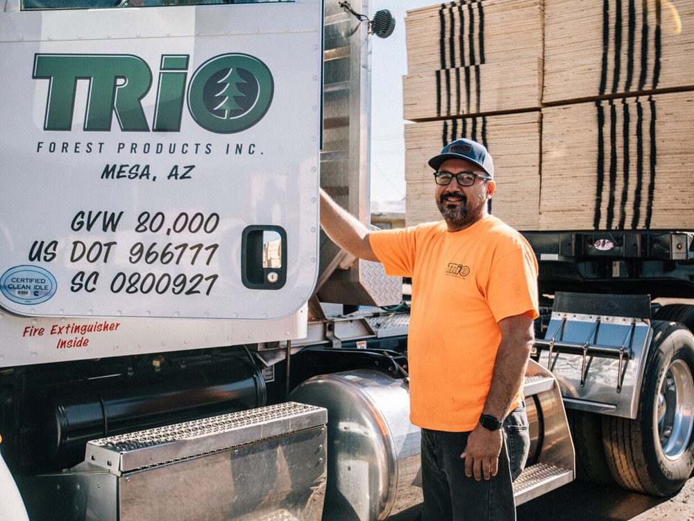 Truck driver standing beside loaded vehicle