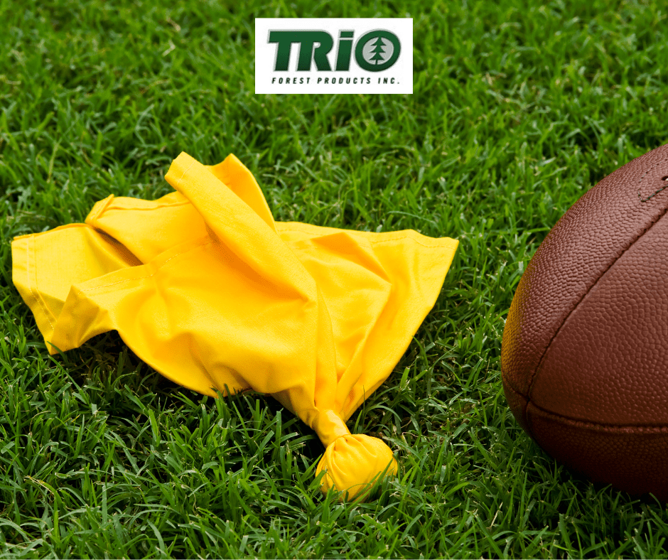 Football and penalty flag on grass