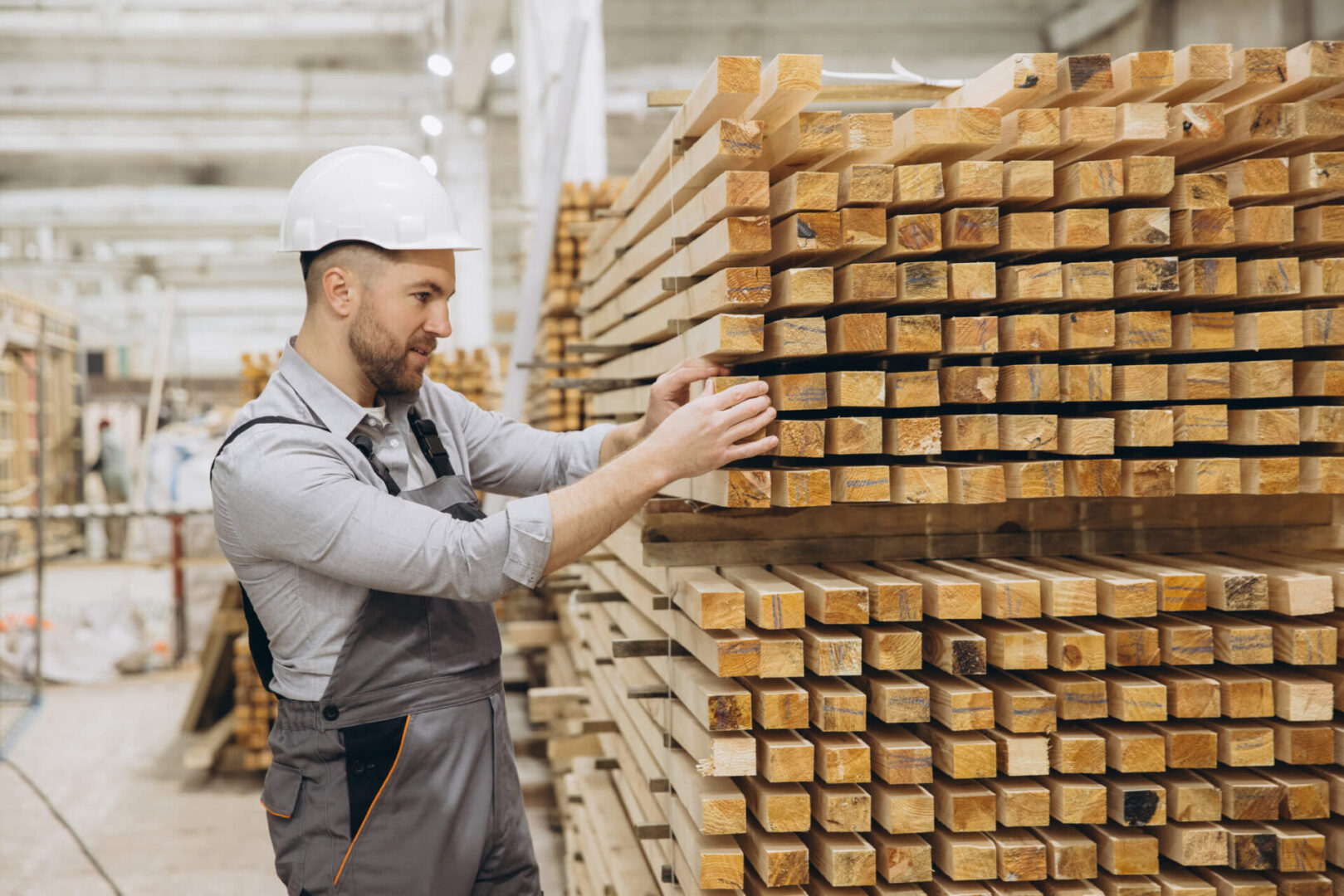 Carpenter arranging lumber in workshop