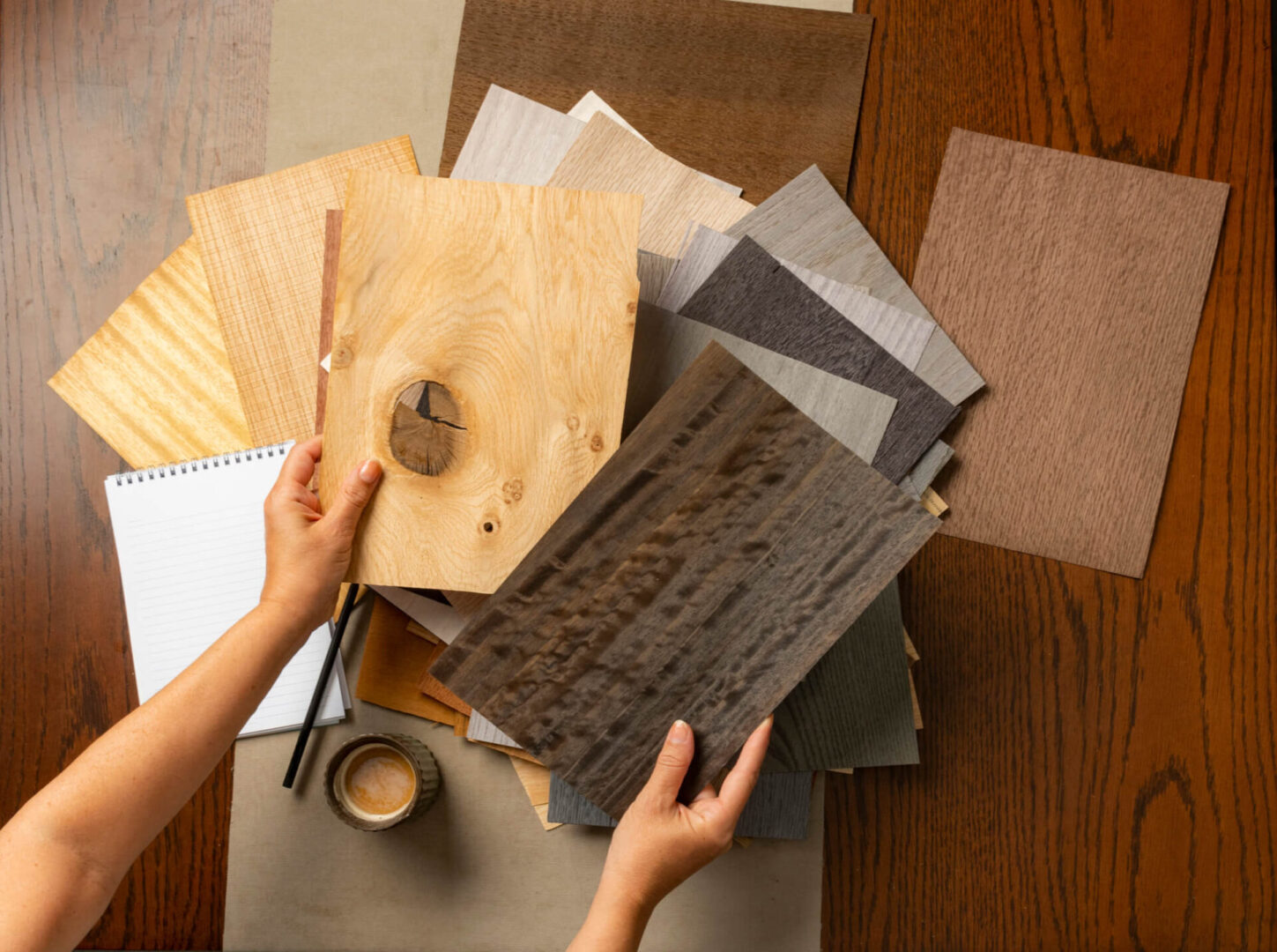 Hands examining wood texture samples